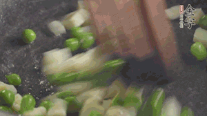 鍋中油7成熱時，入青豆、筍丁翻炒，然后加糯米飯加鹽均勻翻炒。