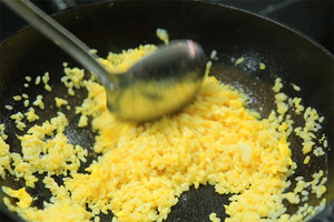 大火加熱炒鍋，再入油，燒到四至五成熱時(shí)倒入雞蛋液，在未凝結(jié)之前，加米飯煸炒，不停翻炒并用鍋鏟將成塊的米飯碾開、撥散。