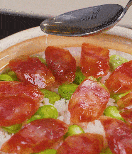 大米出現(xiàn)小孔時(shí)開蓋放香腸，往鍋邊淋入少許油，再燜煮8~10分鐘左右。