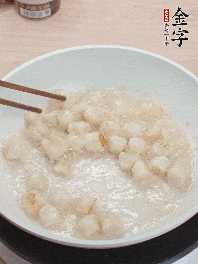 油溫4成熱，鮮貝蘸干淀粉下鍋煎，一面微黃后翻面。