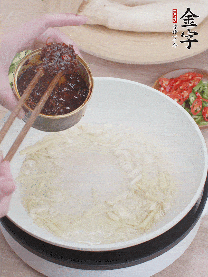 起鍋熱油，姜蒜、金字火腿干貝醬煸香。