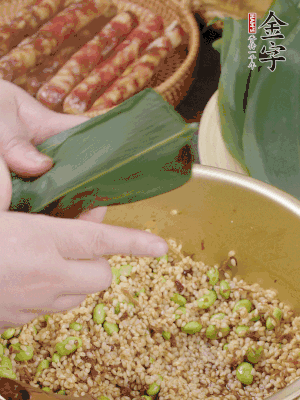 粽葉往下折，完全蓋住，兩側(cè)捏緊。