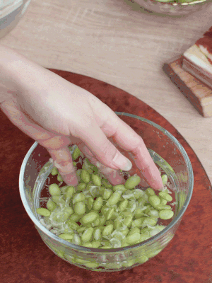 青豆剝殼，搓去外衣。