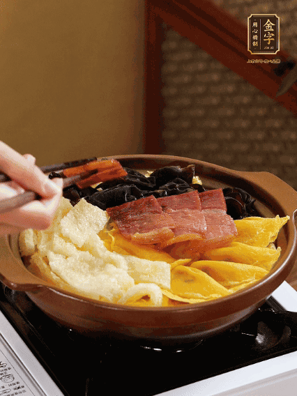 砂鍋底部鋪上娃娃菜，依次擺上肉皮、蛋餃、黑木耳、火腿